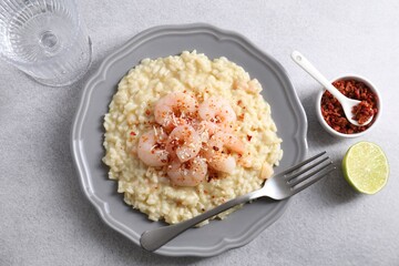 Delicious risotto with shrimps and cheese served on light grey table, top view