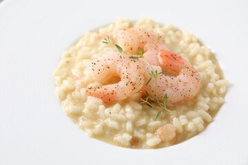 Delicious risotto with shrimps and cheese on plate, closeup