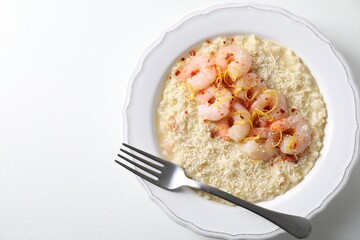 Delicious risotto with shrimps and cheese on white table, top view. Space for text
