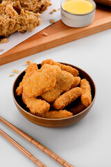 chicken nuggets in brown wooden bowl with cheese sauce