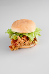 burger with burger bun, lettuce, and crispy chicken and very delicious sauce with white background