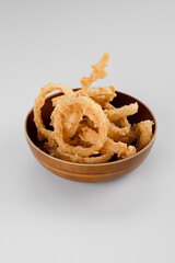 crispy onion ring fries in a wooden bowl.