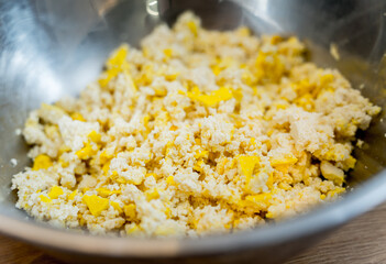 Chef at the kitchen preparing tofu scramble with vegetables