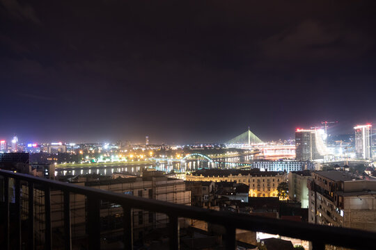 Illuminated suspension bridge and city lights reflected at night