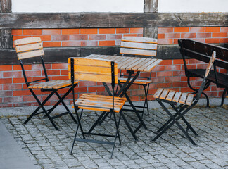 metal and wooden chairs with table placed outside 