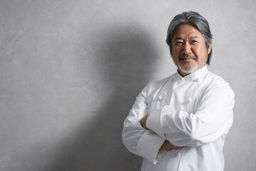 Gray-backed cook (chef) man with arms folded, looking at camera, with space for photocopying