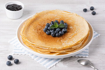 Crepes, thin pancakes with blueberry jam and fresh berries.
