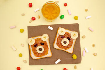Funny cute bear faces sandwich toast bread with peanut butter, banana,nuts, juice,marshmallow. Kids childrens baby's sweet dessert healthy breakfast lunch food art on plate