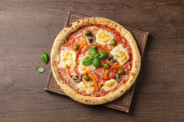 Delicious vegetarian pizza on wooden table, top view