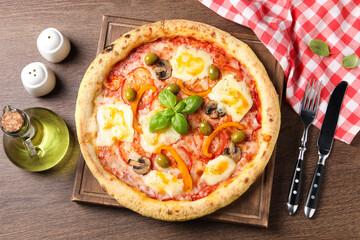 Delicious vegetarian pizza served on wooden table, flat lay