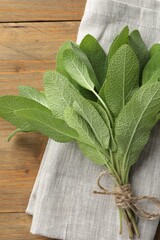 Bunch of green sage leaves on wooden table, top view