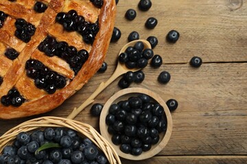 Tasty homemade pie with blueberries served on wooden table, flat lay