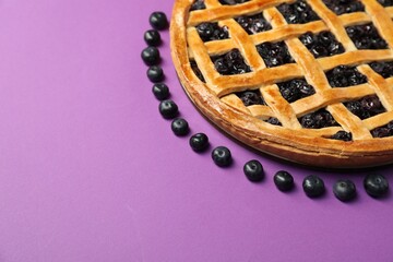 Tasty homemade pie with blueberries on purple table, closeup. Space for text