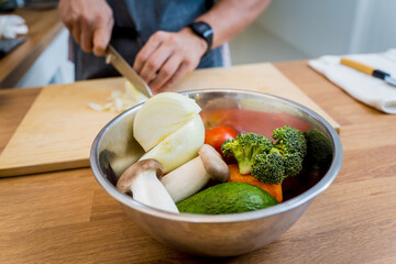 Chef at the kitchen preparing healthy quinoa bowl with avocado