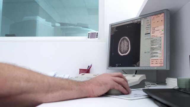 In a high-tech control room, a radiologist reviews brain scan results on monitors while a patient undergoes an MRI or CT scan. Ideal for showcasing advanced medical diagnostics and equipment.