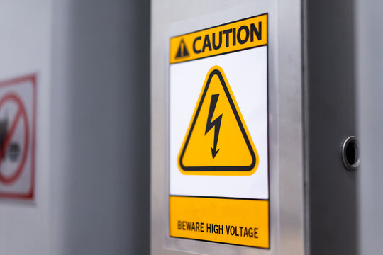 Caution sign: Beware of high voltage on the wall of the building, safety concept