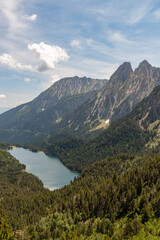 Mountain panorama on two peaks with forest and lake in the valley