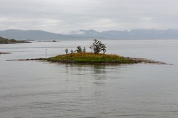 Small island with vegetation in the middle of the sea