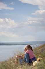 Happy family mom and child daughter rests sitting on the grass on the mountain with a sh. copy space. Slow life. Enjoying the little things. spends time in nature in summer. Lykke concept