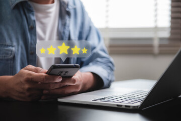 Customer review good rating feedback concept, A person using a smartphone to leave a 5-star review,...