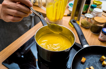 Chef at the kitchen preparing pumpkin porridge with tofu and vegetables