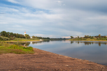 View of the Sukhona River in Totma town at sunset. The dome of an old church can be seen in the...