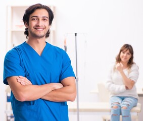 Young male foctor and female patient in blood transfusion concep