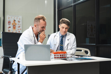 Doctor taking a blood sample tube from a rack with machines of analysis in the lab background, Technician holding blood tube test in the research laboratory.