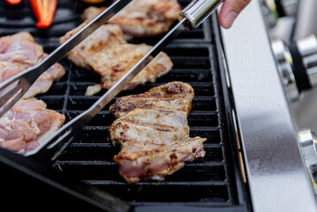 Grilled chicken meat with vegetables on barbecue grill with smoke.