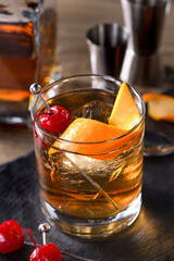 Cocktail Old Fashioned is an old-fashioned sophistication of whiskey and sweet syrup. Served with ice, orange zest and Maraschino cherry. 
