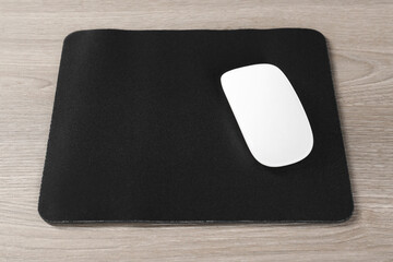Wireless mouse and mousepad on wooden table