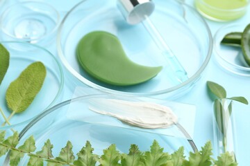 Petri dishes with different fresh leaves and cosmetic products on light blue background, closeup