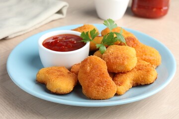 Tasty chicken nuggets with chili sauce and parsley on wooden table, closeup