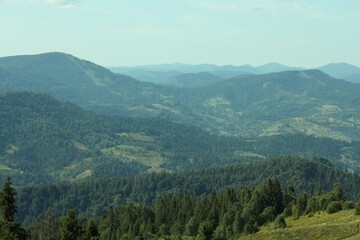 Picturesque view of mountains with trees under sky
