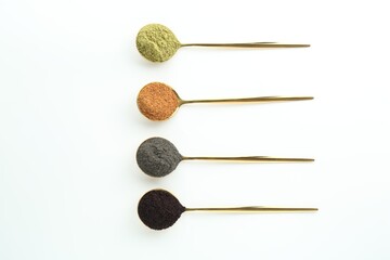 Spoons with different superfood powders on white background, flat lay