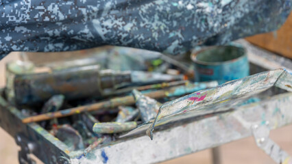 A tray of paint brushes and other art supplies