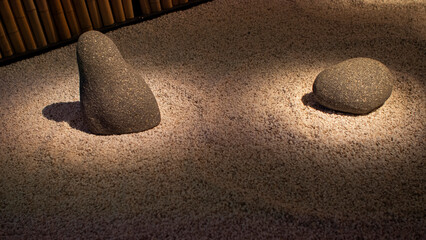 Set of grey granite stones on small white gravel in a minimalist Japanese garden.