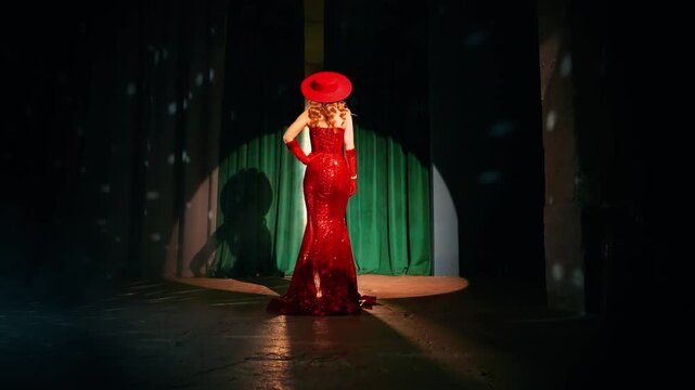 sexy happy woman opens curtains throws drapesthe artist leaves stage unrecognizable silhouette go away, rear view in back lit, long red dress hat. Girl Retro lady old style 20s new year party room