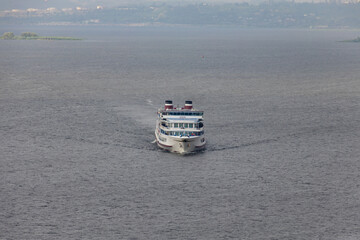 A four-deck twin-tube cruise ship on a river, sea or lake.