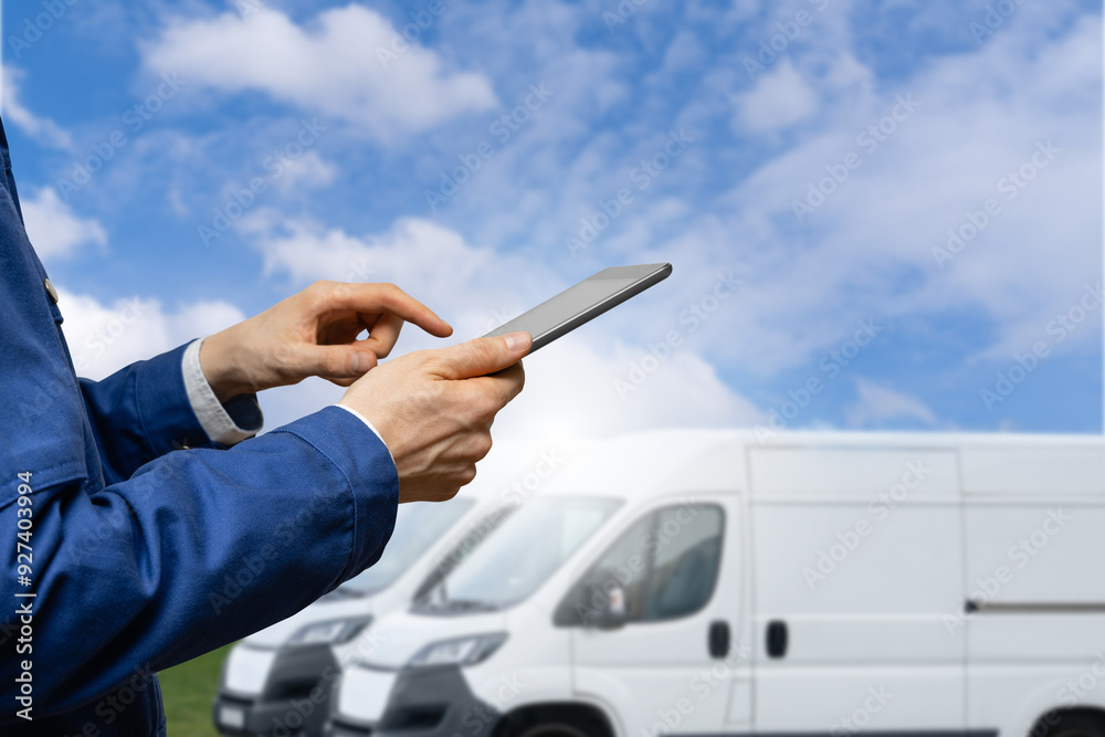 Poster Manager with a digital tablet on the background of vans. Fleet management.