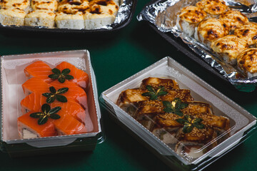 Sushi in delivery boxes on the table and chopsticks