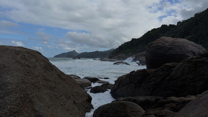 Fototapeta premium Slow motion waves crashing on a rugged paradise island coast