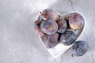Ripe plums on a light background