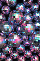 A Collection of Reflective Disco Balls with a Multicolor Mosaic Pattern on Black Background. The disco balls feature a mesmerizing array of pink, blue, and silver tiles that reflect light