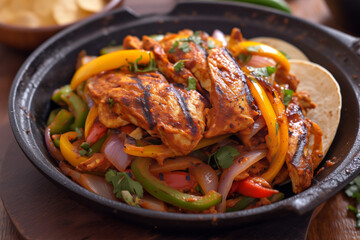 flavorful fajitas in a hot skillet with charred peppers onions and marinated chicken, a hearty and vibrant mexican favorite