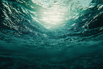 captivating underwater view of the ocean surface with sunlight rays streaming through the water creating a glowing effect