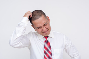 A frustrated middle aged asian manager scratches his head at slumping sales and incompetent employees. Annoyed at poor business performance. Isolated on a white background.