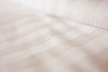 Pillow and bedsheet on empty bed, close up and blur background. Soft and calm atmosphere of cozy bed room. 