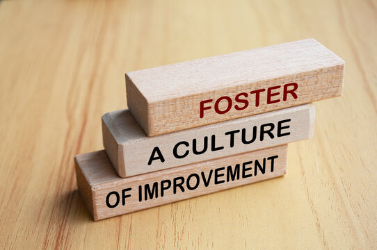 Foster a culture of improvement text on wooden blocks. Operational excellence and continuous improvement concept
