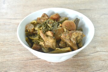 boiled mixed vegetable with braised pork bone in black soybean soup in bowl on table  